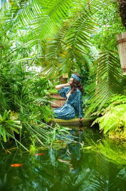 Tropik tatil köyünde yaz kıyafetleri giyen bir kadın.