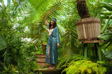 Tropik tatil köyünde yaz kıyafetleri giyen bir kadın.