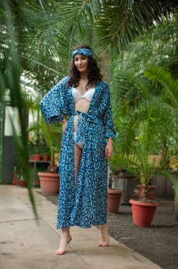 Tropik tatil köyünde yaz kıyafetleri giyen bir kadın.