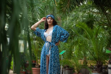 Tropik tatil köyünde yaz kıyafetleri giyen bir kadın.