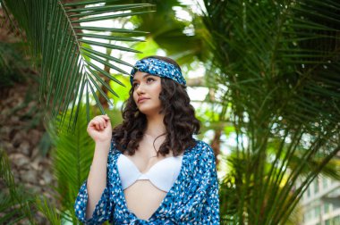 Tropik tatil köyünde yaz kıyafetleri giyen bir kadın.