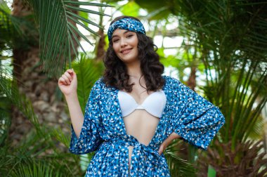 Tropik tatil köyünde yaz kıyafetleri giyen bir kadın.