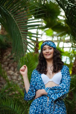 Tropik tatil köyünde yaz kıyafetleri giyen bir kadın.