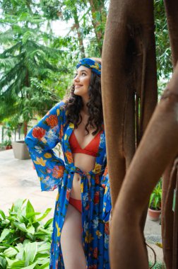 Tropik tatil köyünde yaz kıyafetleri giyen bir kadın.