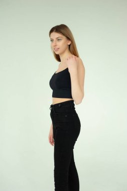 Stüdyoda siyah giysiler içinde poz veren güzel bir kadın.