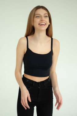 Gri arka planda poz veren güzel genç kadın