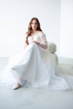 Beyaz gelinlikli, uzun saçlı, güzel bir kadın.