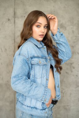 Stüdyoda poz veren mavi ceketli güzel genç bir kadın. moda portresi