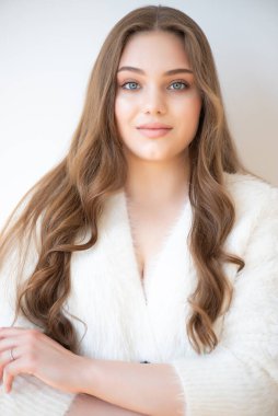 Stüdyoda doğal makyajlı genç bir kadının portresi.