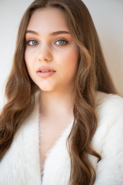 Uzun kahverengi saçlı ve güzel gülüşlü genç bir kadın..