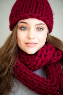 Örgü şapkalı, elinde eşarp olan güzel bir genç kız. Yaklaş.