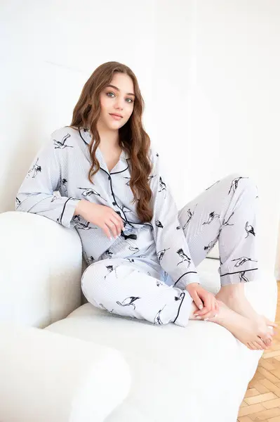young woman with pajamas in pajamas sitting on the sofa