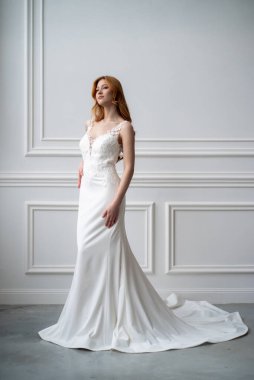 Beyaz gelinlik içinde, düğün saç stili olan genç ve güzel gelin.