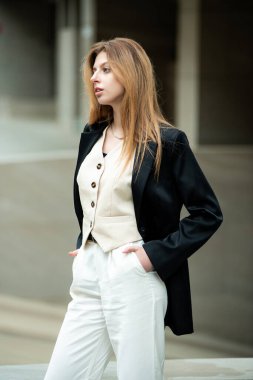 Beyaz gömlek ve pantolon giyen güzel genç bir kadın.