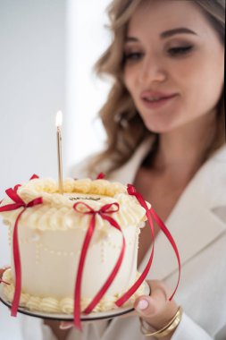 Elinde pastayla mum tutan bir kadın.