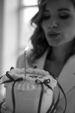 Güzel bir kadın pasta tutuyor ve doğum gününü kutluyor.