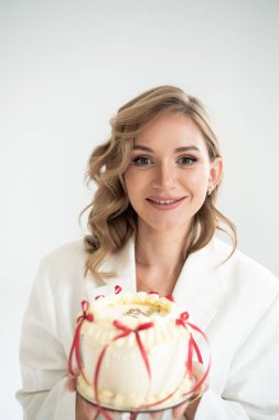 Beyaz pastalı ve kırmızı güllü genç kadın.