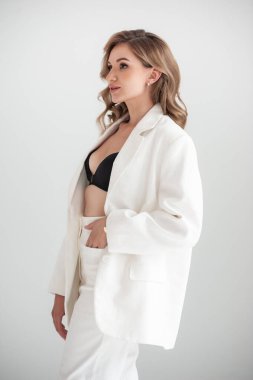 Beyaz takım elbiseli ve beyaz ceketli güzel bir kadının portresi.