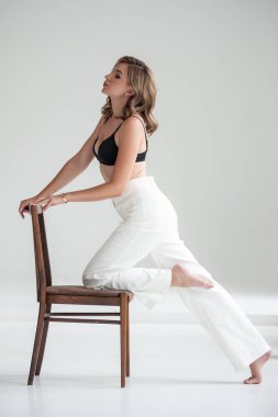 Stüdyoda beyaz gömlekli genç bir kadın oturuyor.