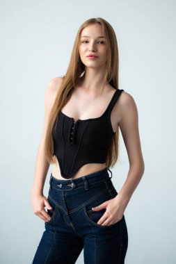 Mavi bluzlu ve kot pantolonlu genç kadın.