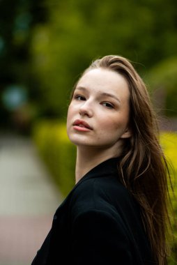 Beyaz önlüklü güzel bir kız parkta yürüyor..