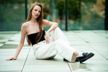 Beyaz elbiseli ve siyah şapkalı güzel bir esmer kızın portresi.