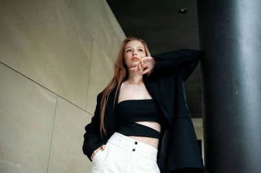 Şehirde siyah ceketle poz veren güzel bir kız.