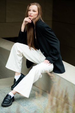 Şehirde siyah takım elbiseli güzel bir kızın portresi.