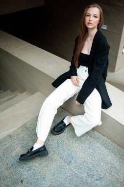 Şehir sokaklarında poz veren uzun saçlı güzel bir genç kız.