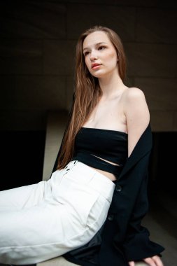 Şehrin sokaklarında poz veren uzun saçlı genç bir kız.