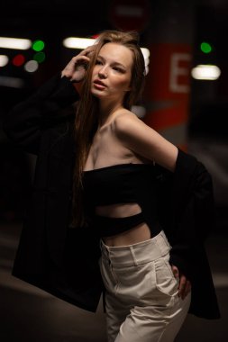 Genç güzel bir kadın şehirde poz veriyor.