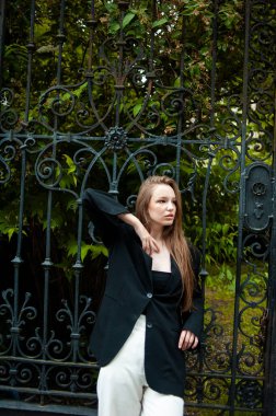 Eski bir binanın arka planında genç bir kadının portresi.