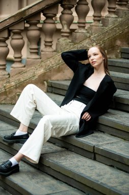 Beyaz önlüklü ve kot pantolonlu genç model kadın.