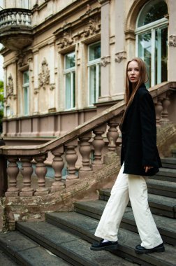 Güzel kız parkta merdivenlerde yürüyor.