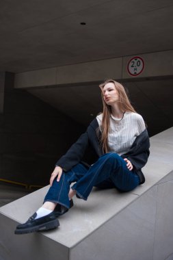 Genç bir kız merdivenlerde dinleniyor..