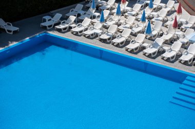 Otelde güneşlenen mavi yüzme havuzu
