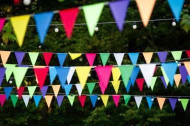 Parkta asılı renkli bayraklar. Kutlama için renkli kiraz kuşu