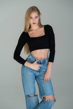 Gri duvara karşı poz veren genç kız