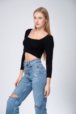 Beyaz arka planda kot pantolon giymiş güzel bir sarışının portresi. moda ve tarz kavramı