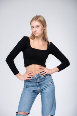 Stüdyoda poz veren genç kız, beyaz arka planda izole edilmiş.