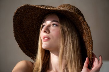 Hasır şapka takan güzel bir kadın ve arka planda bir fotokopi alanı olan bir hasır şapka.