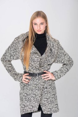 Beyaz arka planda siyah ceketli genç bir kadın.