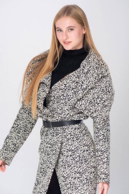 Elleri arkada poz veren genç bir kadın.