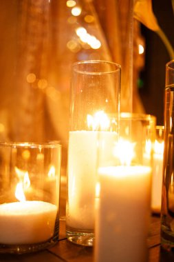 Odadaki masada cam içinde mum yakmak.