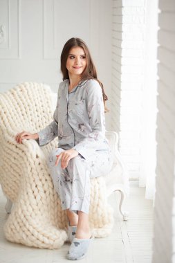 Stüdyoda açık mavi örgülü elbiselerle poz veren güzel bir kadın.