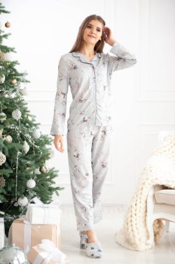 Elinde Noel ağacı olan pijamalı güzel bir kadın. Noel havası..