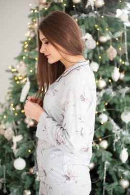 Evdeki Noel ağacında güzel hamile bir kadın. Mutlu yıllar.