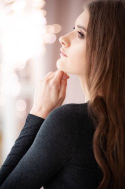 Genç kadın aynaya bakıyor.