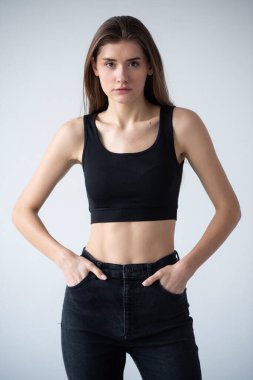 Elleri kalçasında poz veren genç bir kadın.