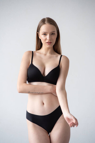 молодая красивая девушка позирует в нижнем белье в студии